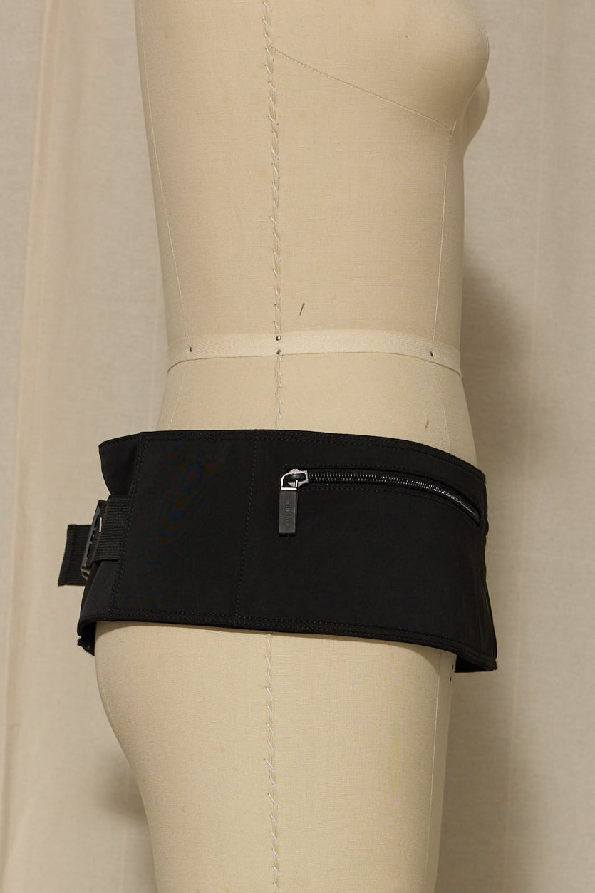 Black waist bag on a mannequin against a neutral background