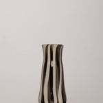 Discover the YAKUSH STRIPS Vase B&W – a 8.6" tall, black-and-white striped handmade recycled glass vase or bottle, ideal for drinks or flowers.