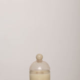 Discover the YAKUSH Candle Snow Queen – a 7" tall soy candle in hand-blown recycled glass, scented with oud, rose, and patchouli, with a 70-hour burn time.