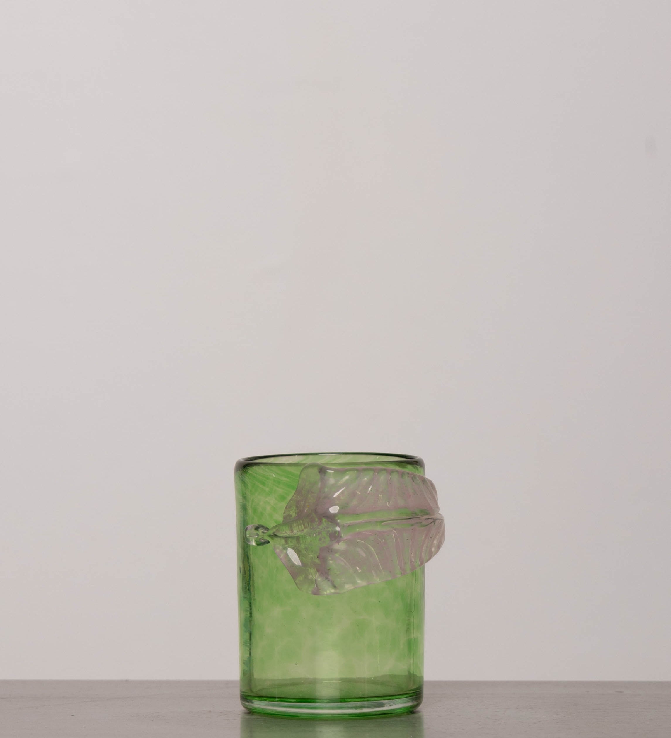 Discover the YAKUSH Botanist Glass Green – a 4.3" tall, 300 ml handcrafted tumbler with a leaf motif, made from recycled hutta glass.