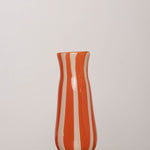 Discover the YAKUSH STRIPS Vase Orange – an 8.6" tall, jam orange striped recycled glass vase, handmade for drinks or floral displays.