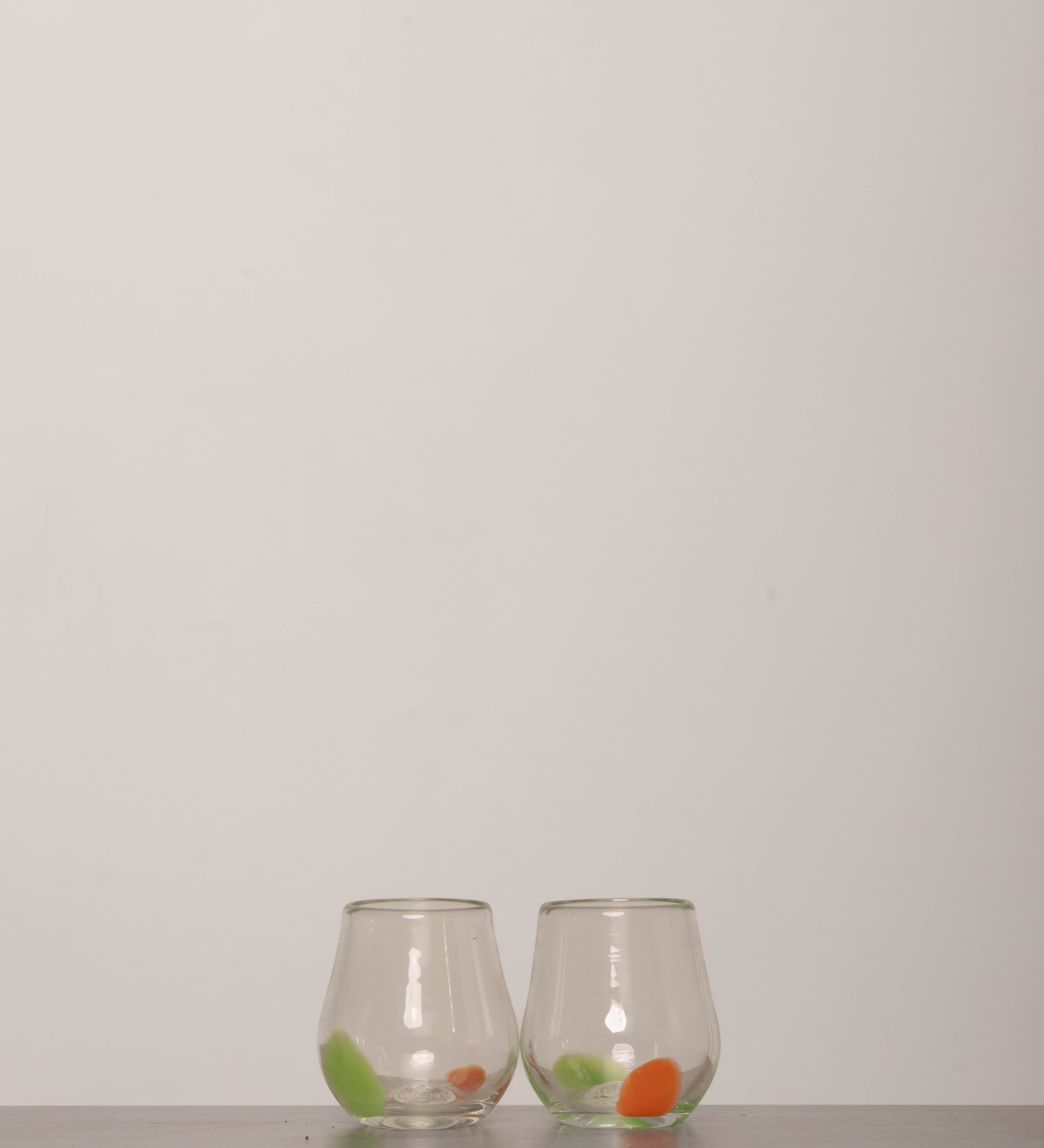 Discover the YAKUSH Tulip Glass – a 3.9" tall, tulip-shaped recycled glass wine glass, handmade with unique color variations.
